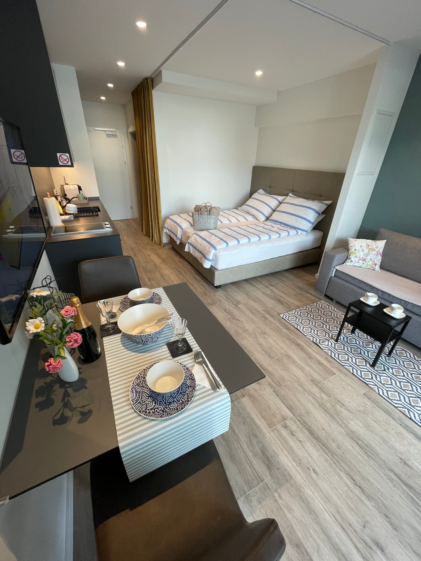 Open-plan studio with queen-size bed, dining table and sofa