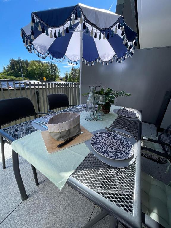 Terrace table set for breakfast under a blue-and-white parasol